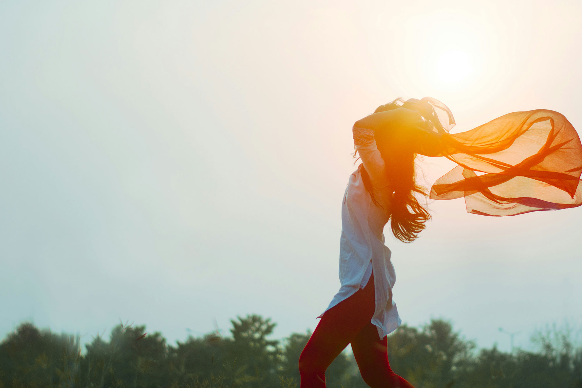 women embracing freedom and confidence with flowing scarf, illuminated by sunlight. Symbolizing empowerment. free webinar growth mindset