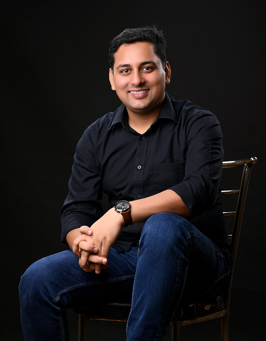 certified mindset Coach Rajendra in a black shirt, wearing a wristwatch, against dark background, radiating motivation