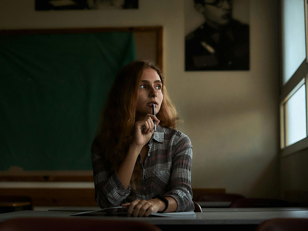 Two women stand confidently at  desk with  computer, symbolizing leadership and empowerment in the workplace
