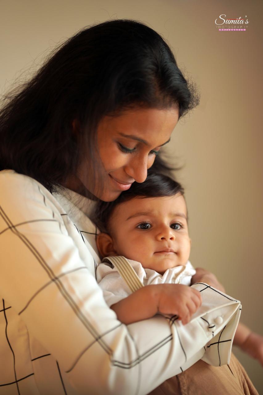 woman dressed in white, holding her child with peaceful expression, symbolizing the impact of emotional well-being 